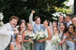 Wedding party celebrates joyfully outdoors with candid group reactions. pequot chapel