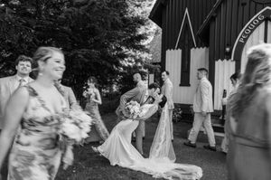 Black and white photo of wedding celebration outside rustic barn venue. pequot chapel