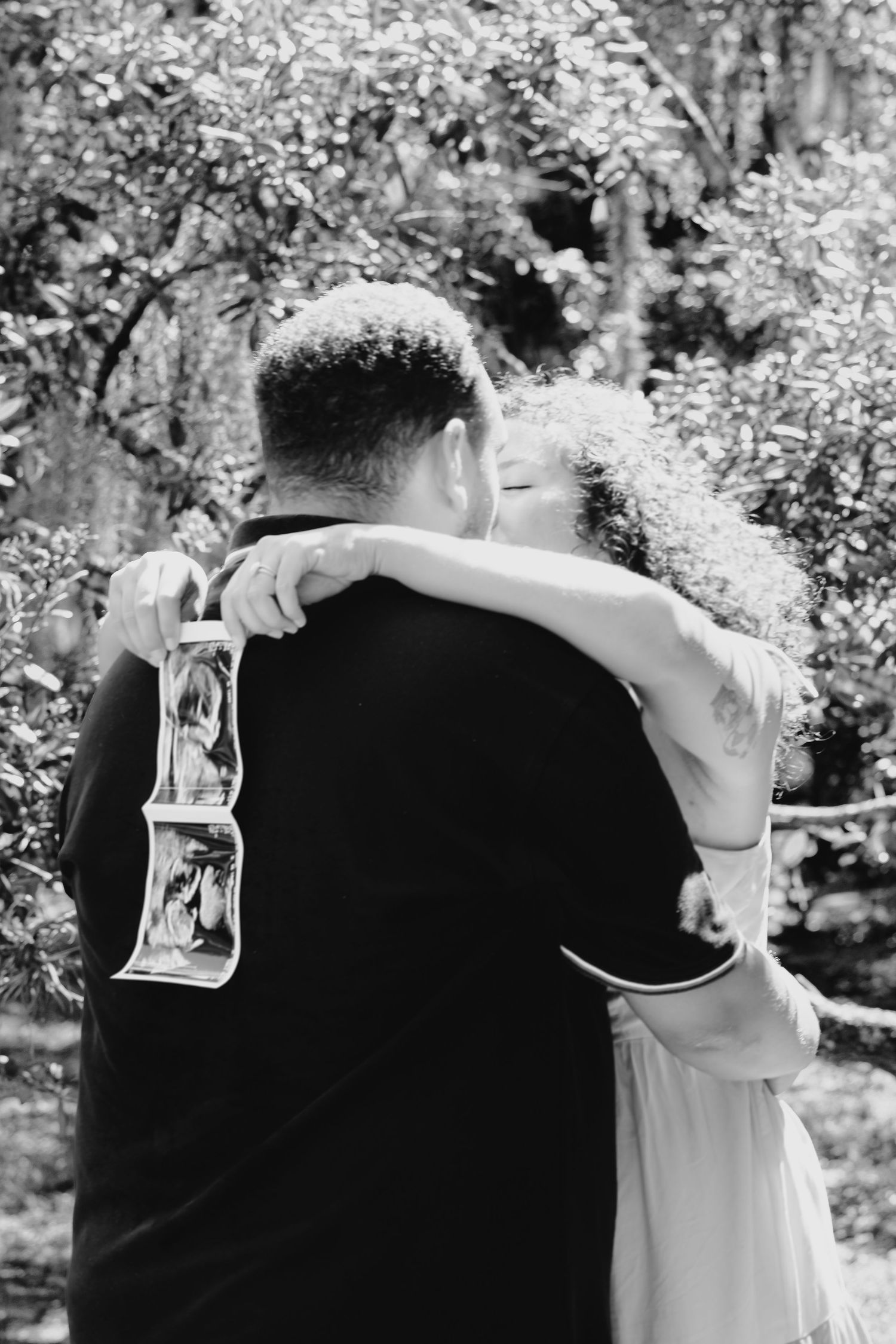 Romantic couple embracing outdoors surrounded by blooming spring flowers.