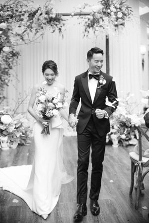 Radiant newlyweds walking hand in hand down the aisle after their elegant wedding ceremony.