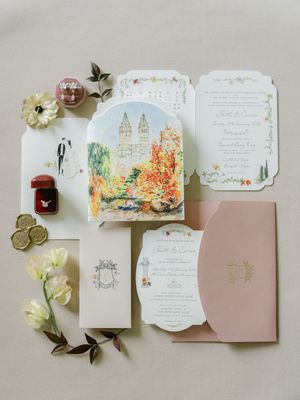 Romantic wedding invitation suite featuring a watercolor Central Park illustration, pink envelopes, and floral details with gold wax seals.