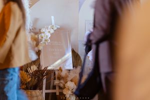 Blurred artistic photo of dried flowers and paper stationery with delicate white blooms in soft lighting.