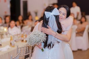 Elegantly decorated wedding reception with dance moments and soft lighting illuminating white floral arrangements.