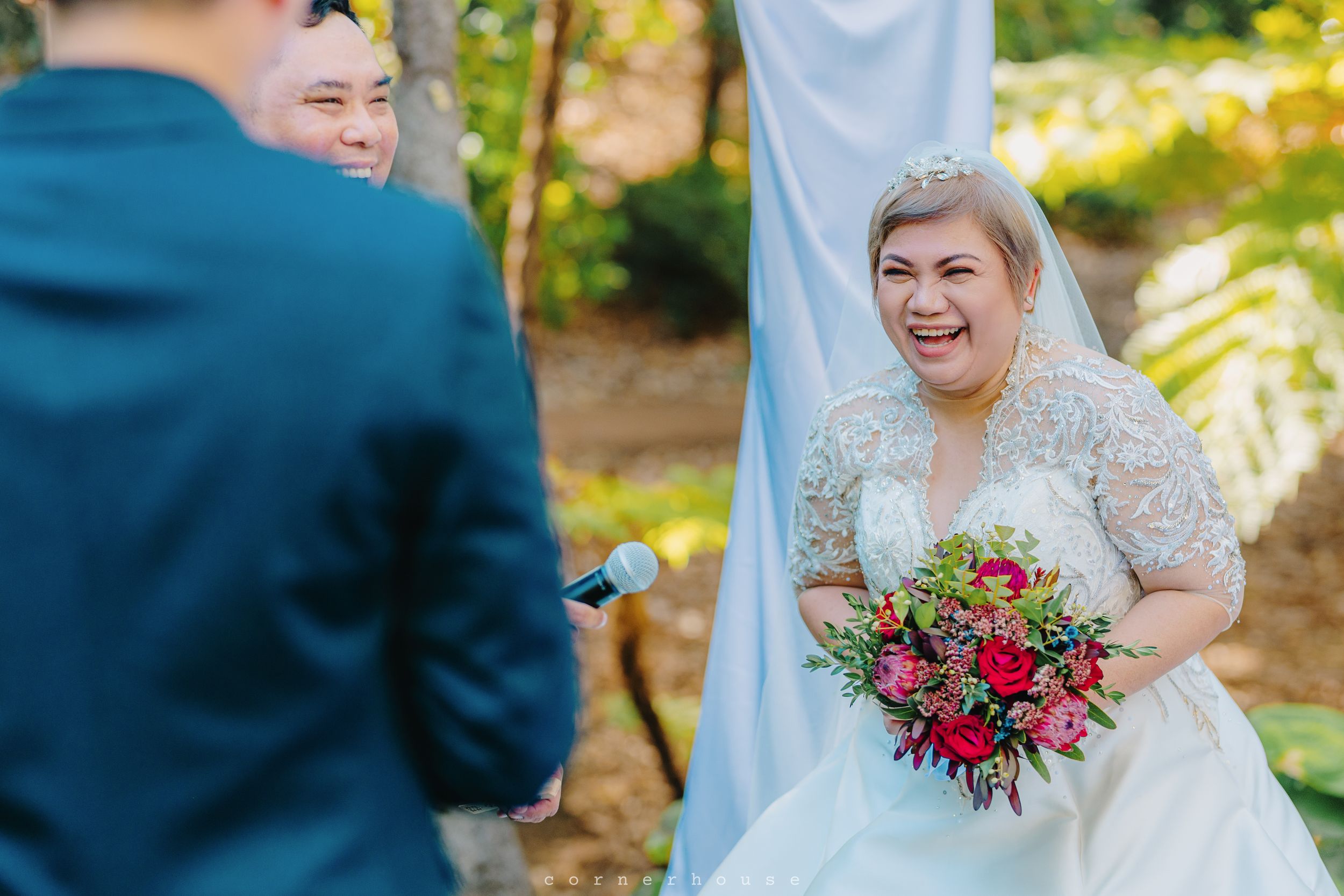 A joyful outdoor wedding moment captured in a garden setting with floral arrangements and blue and white decor.