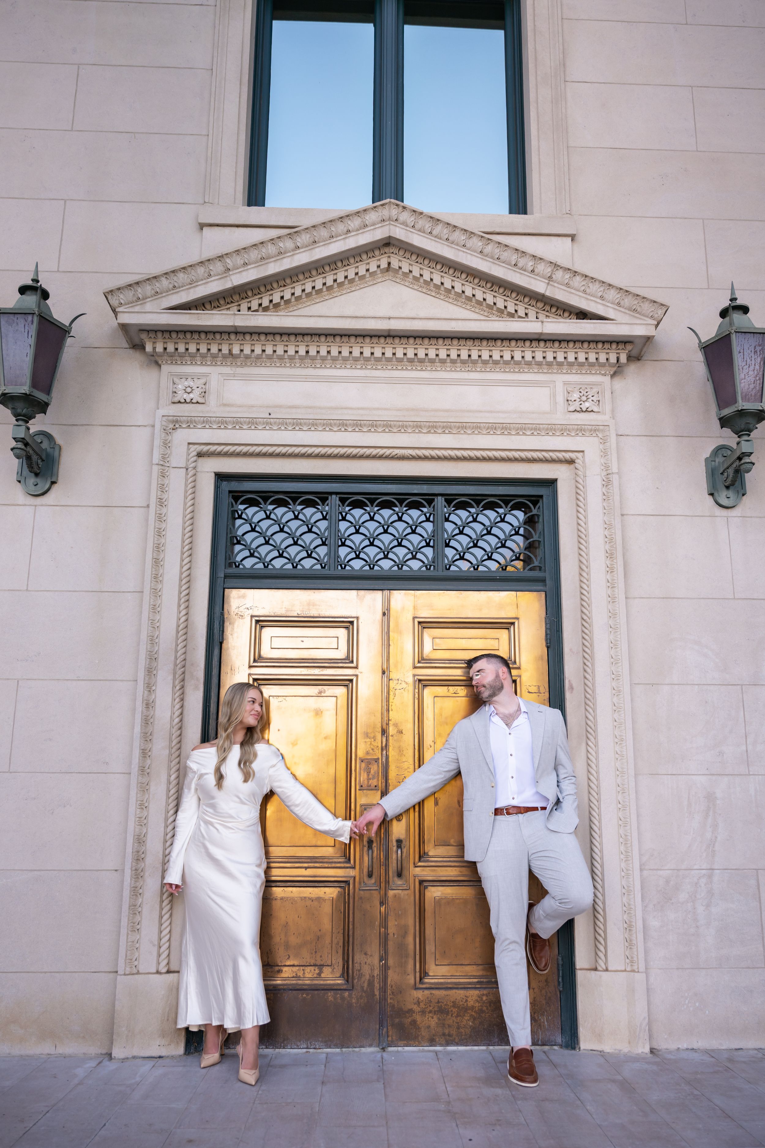 A series of artistic dance poses performed in front of ornate wooden doors on a stone building exterior.