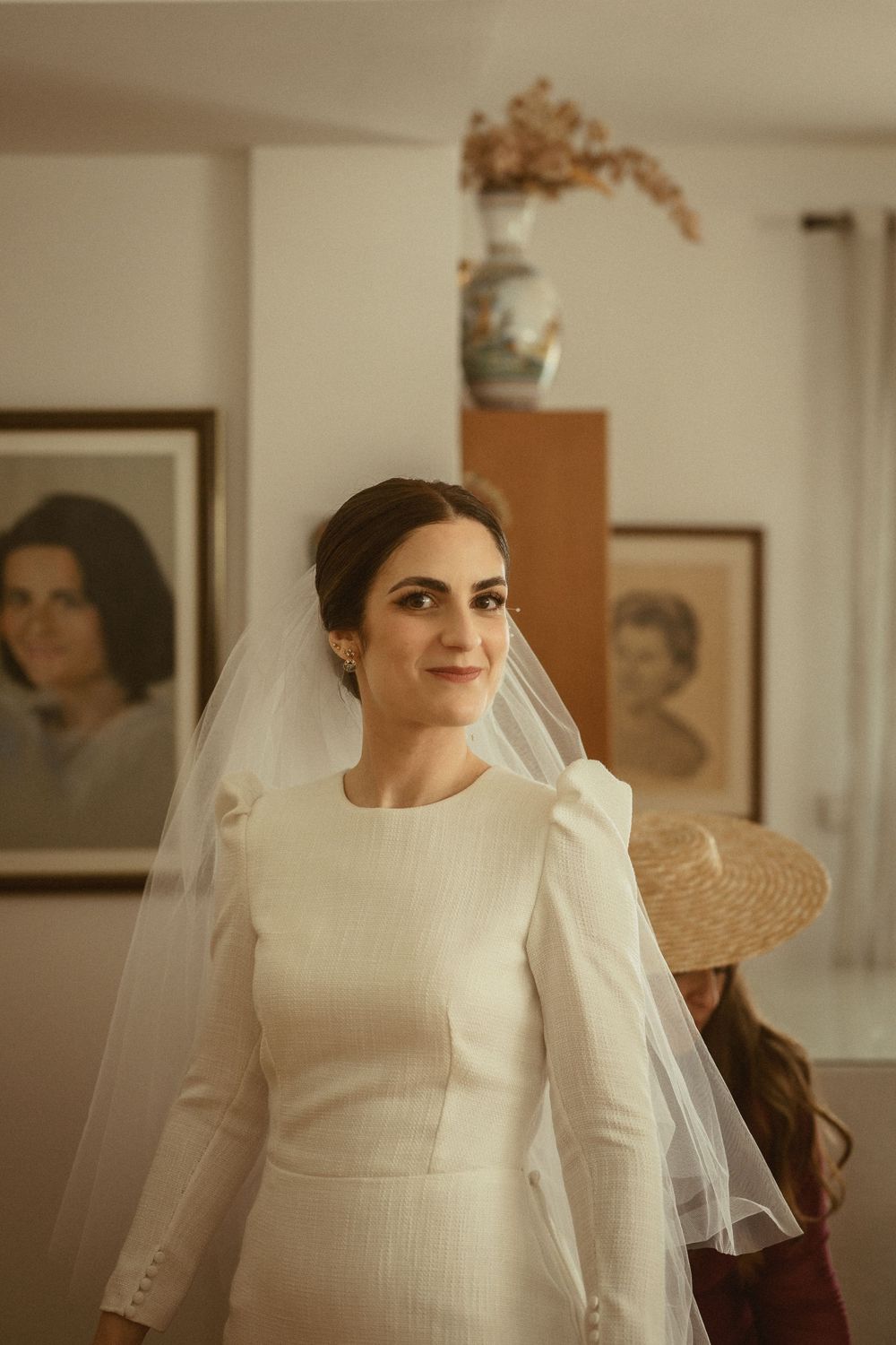 Elegant bridal portrait showcasing a sophisticated long-sleeved white wedding dress and flowing veil.