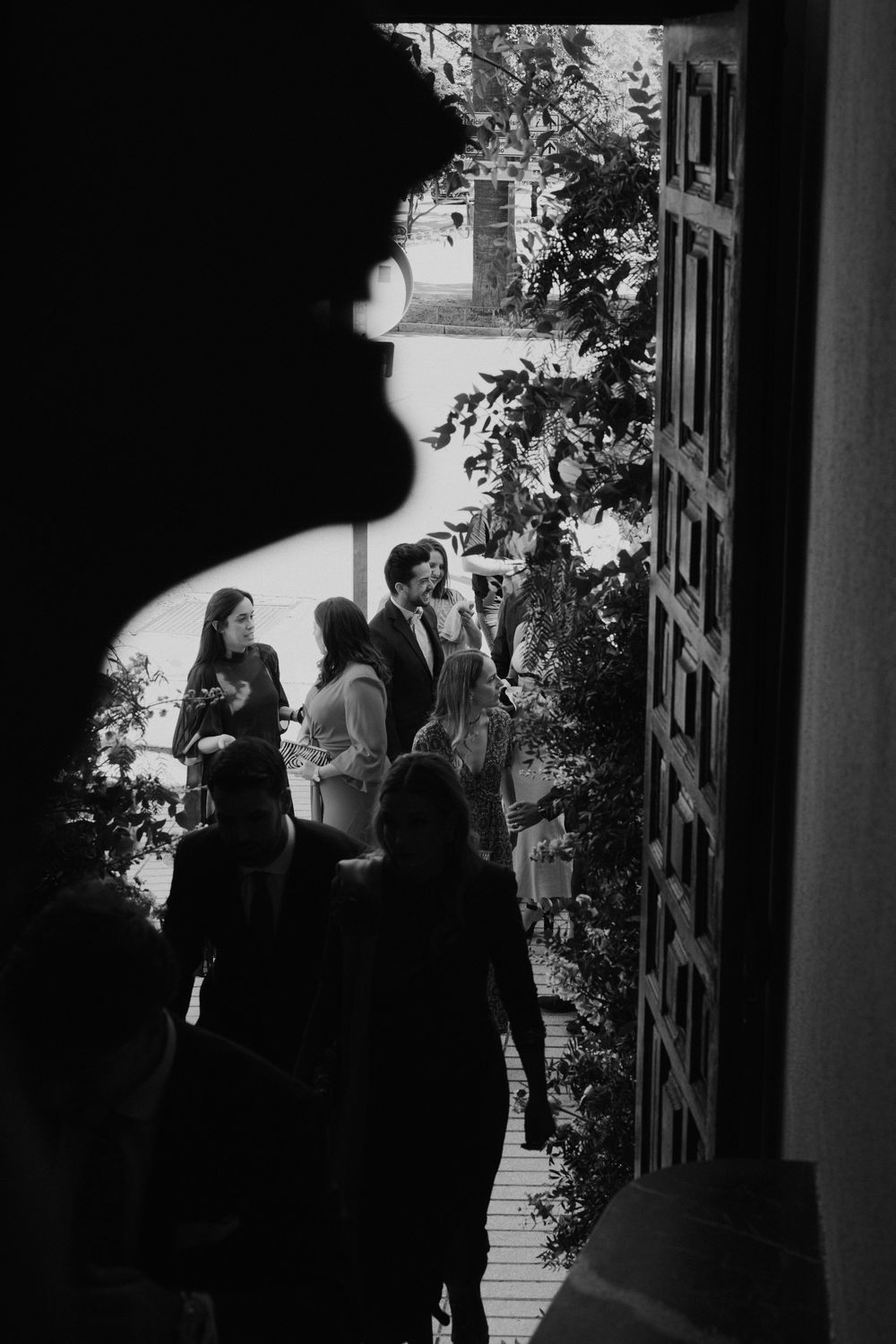 Black and white photo series captures silhouettes of people gathered in a doorway with natural light streaming in.