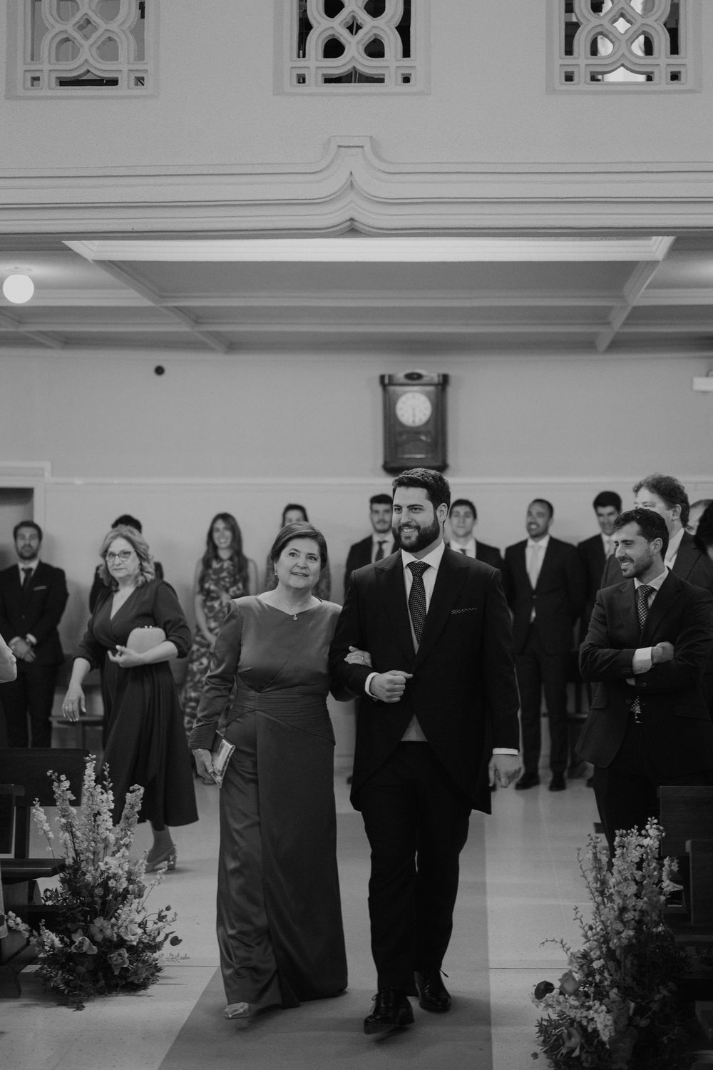 Guests in formal attire dance together at an elegant wedding reception with white decorative elements.