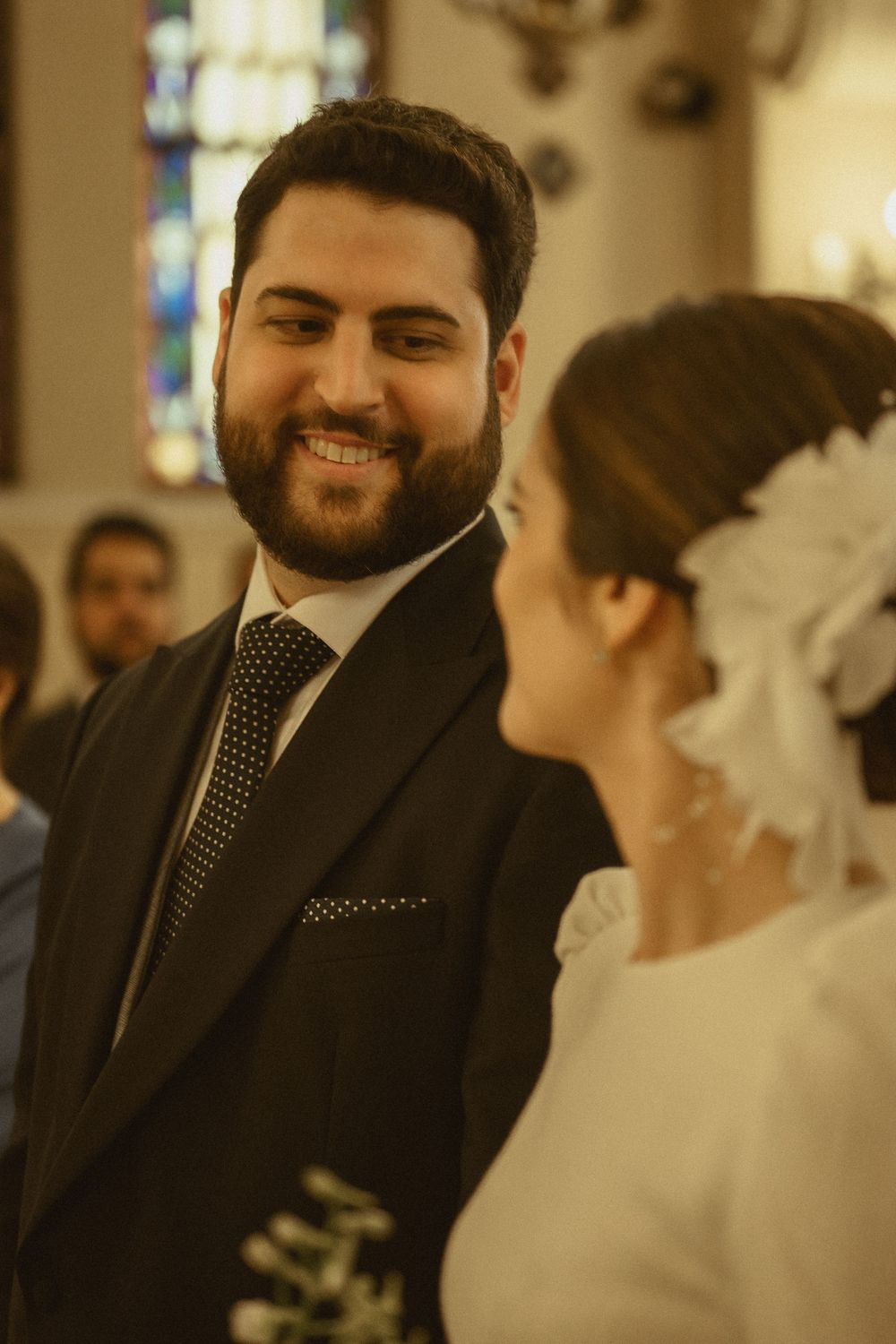 Romantic moment between bride in white dress and groom in black suit during wedding ceremony.