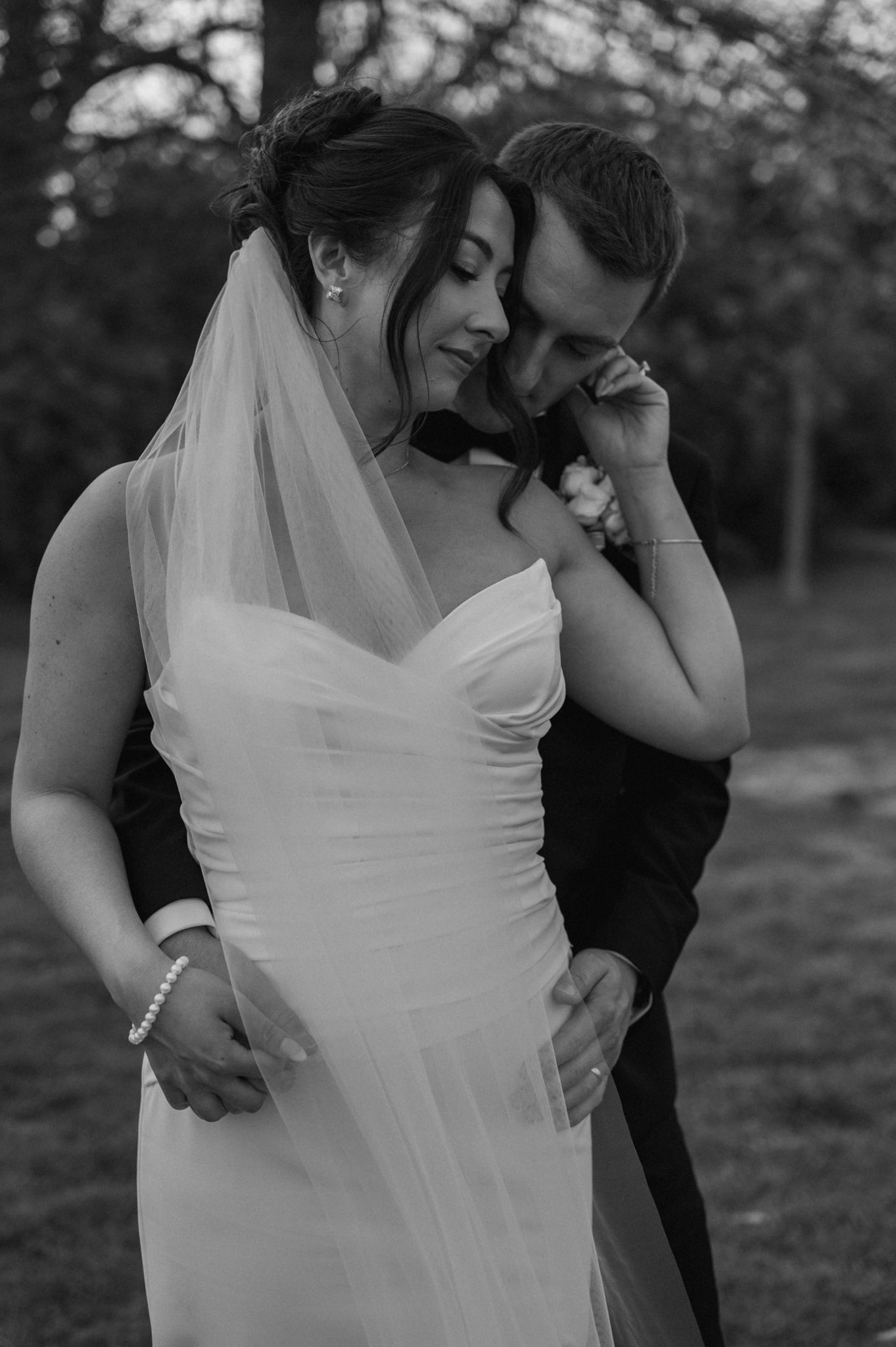 Romantic outdoor wedding portraits of couple embracing in a natural setting.