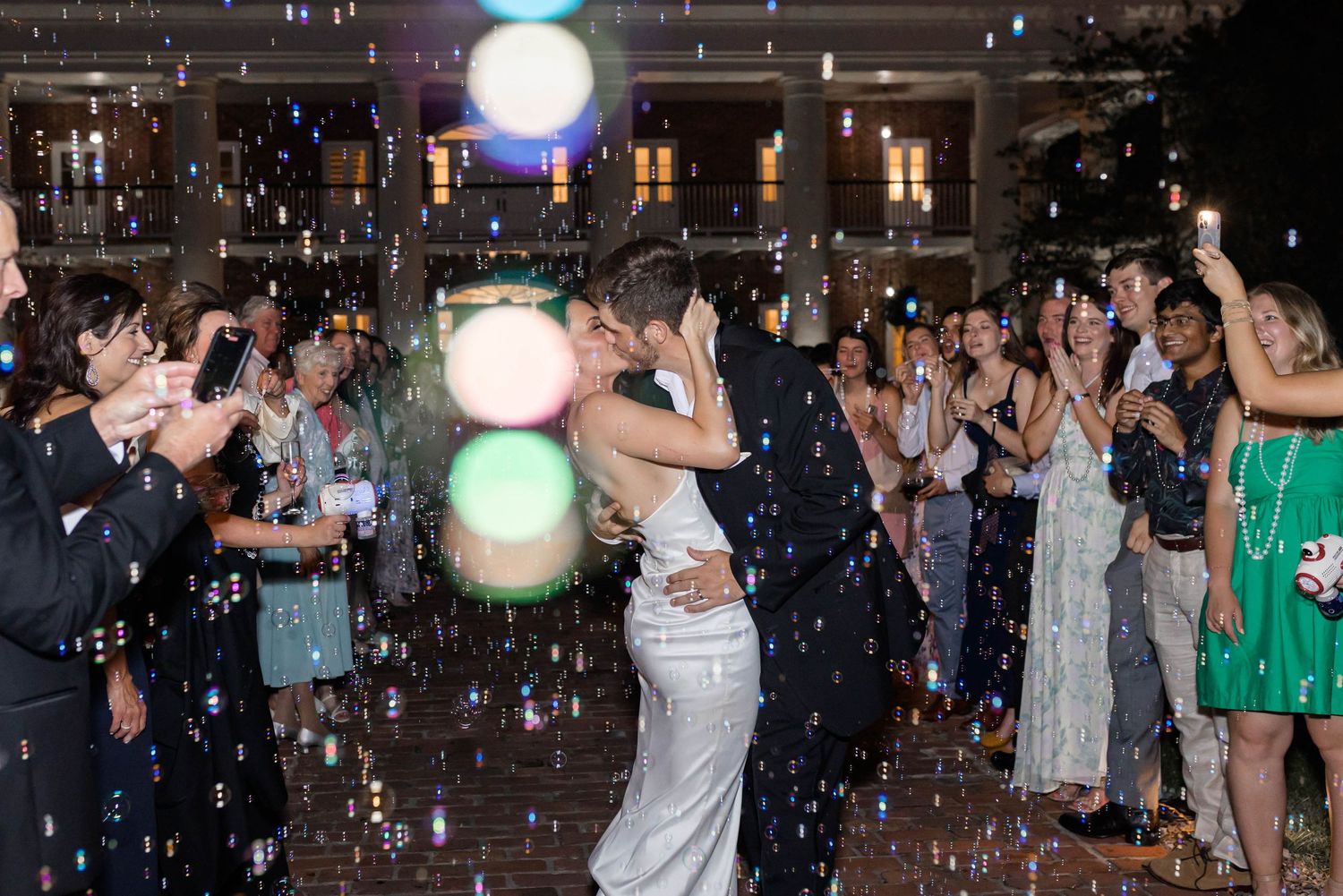 bride and groom kiss during bubble exit