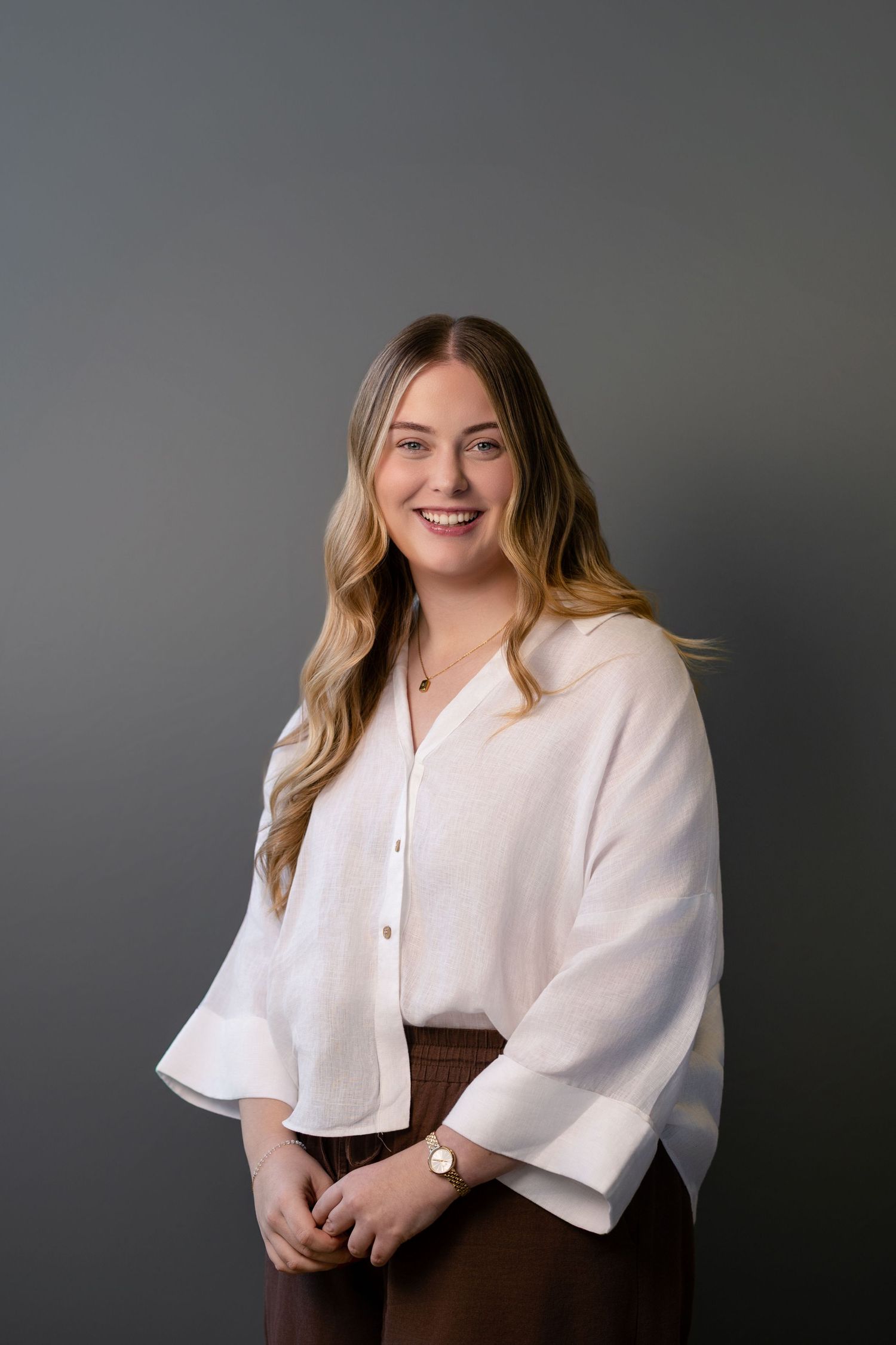 Professional portrait series showing a person in a white button-up top against a dark gray studio background.
