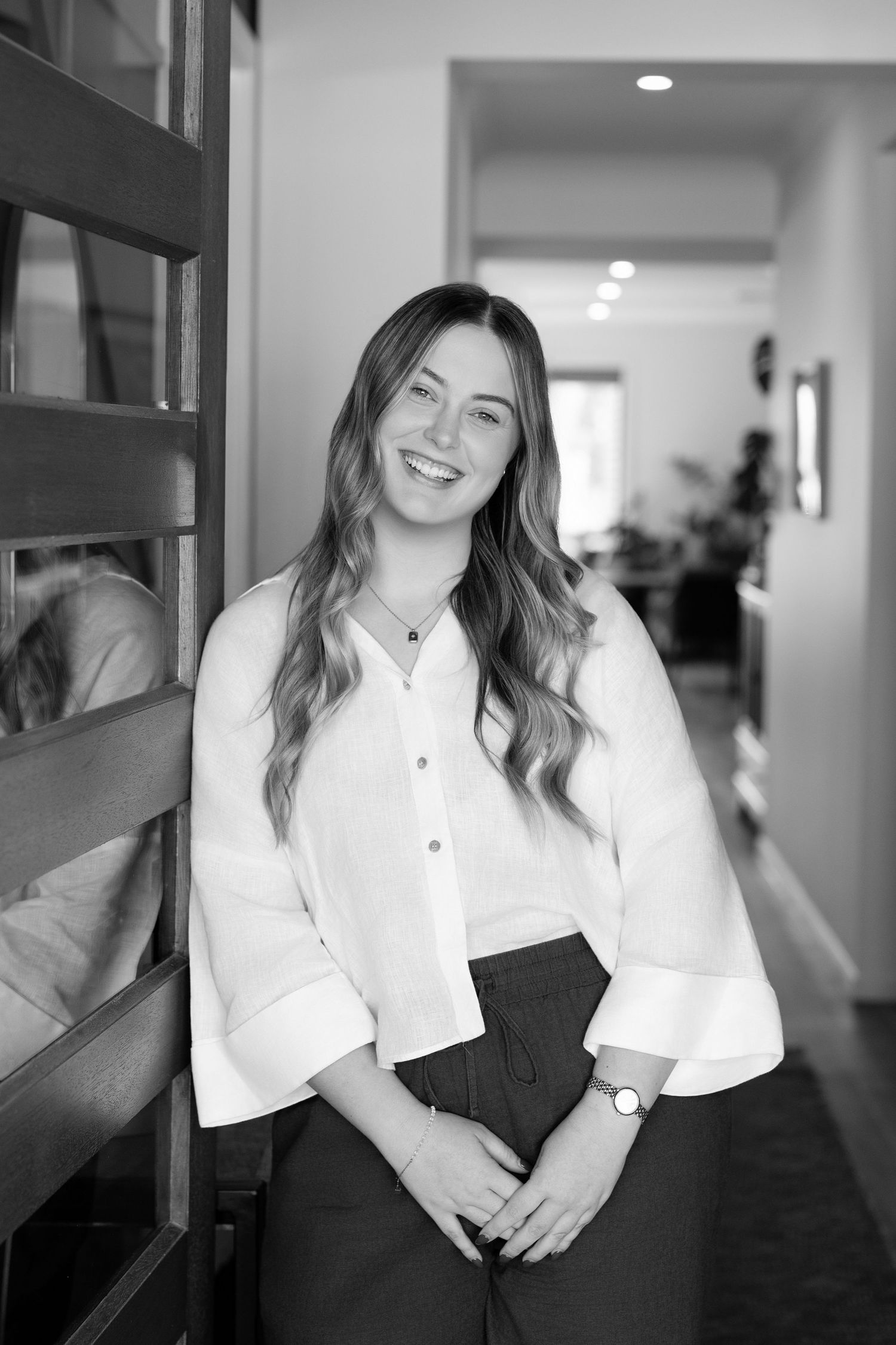 Professional portrait series in black and white showing a person in a white button-up shirt against a blurred hallway background.