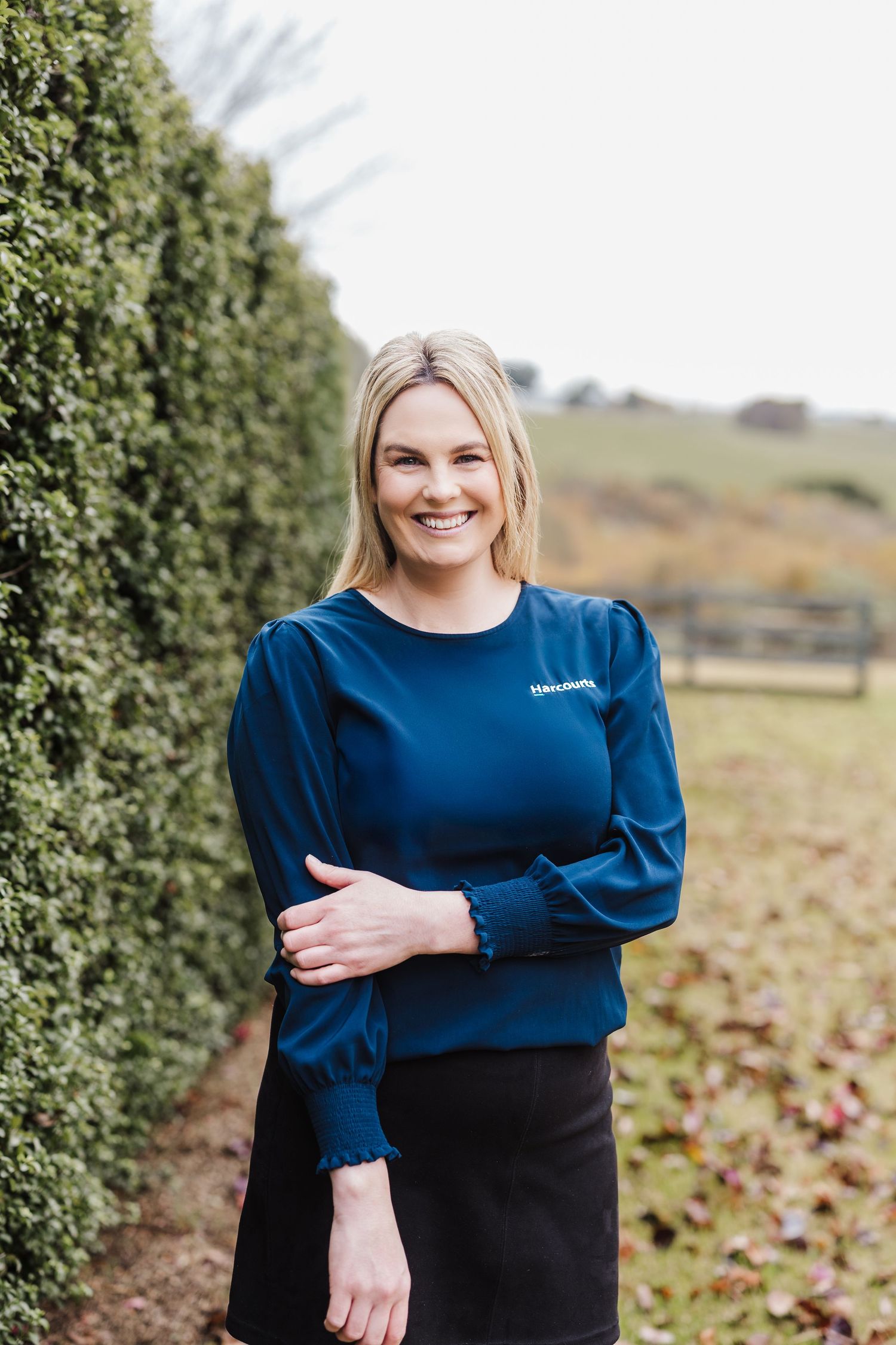 A series of outdoor portraits showing someone wearing a navy blue sweater against a natural garden background.