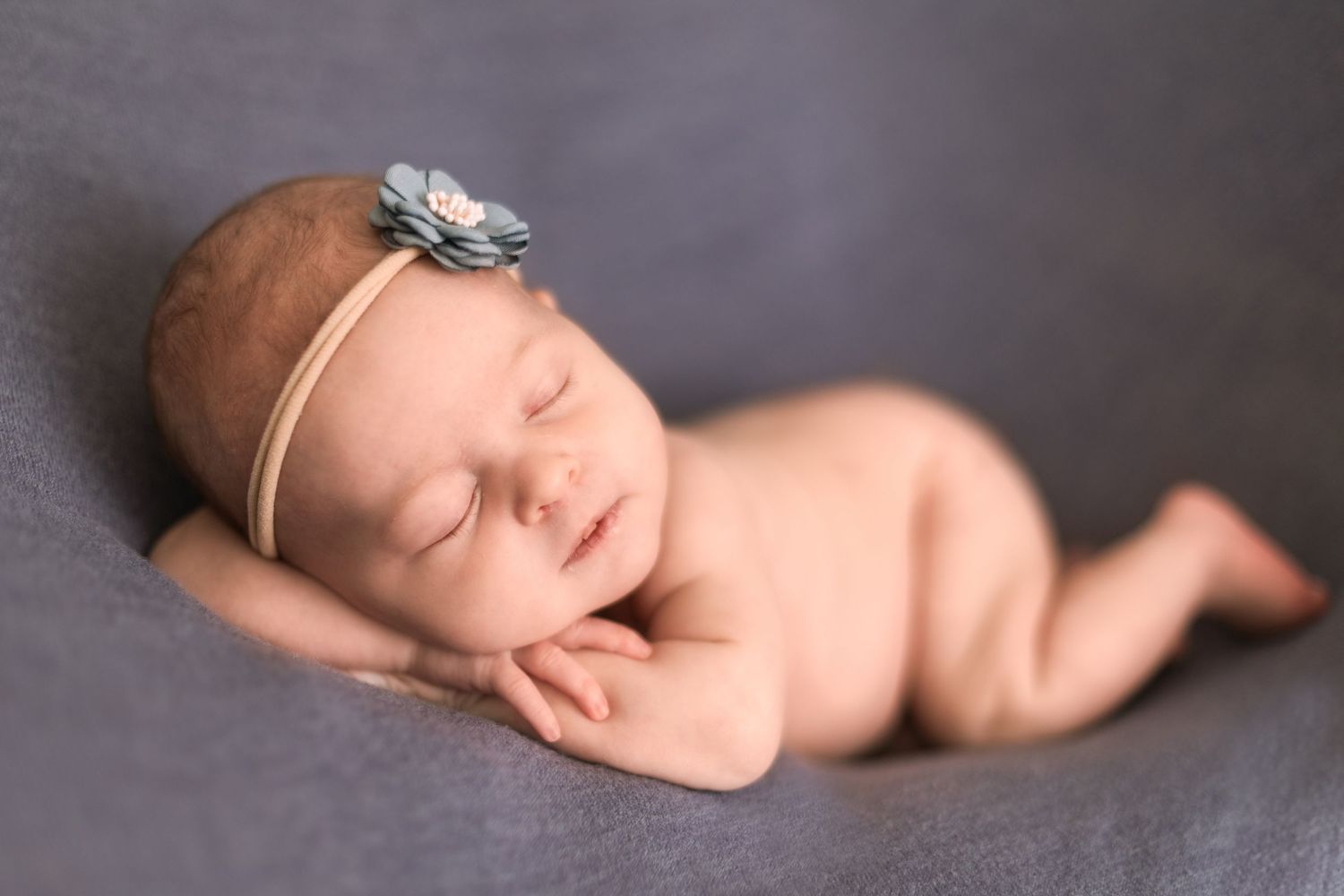 Peaceful newborn photography session with soft lighting and delicate accessories.