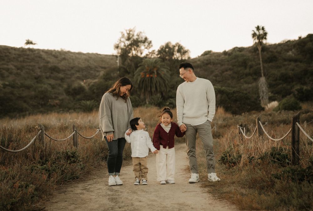 A family walking together on a rustic trail during golden hour with natural scenery in the background.