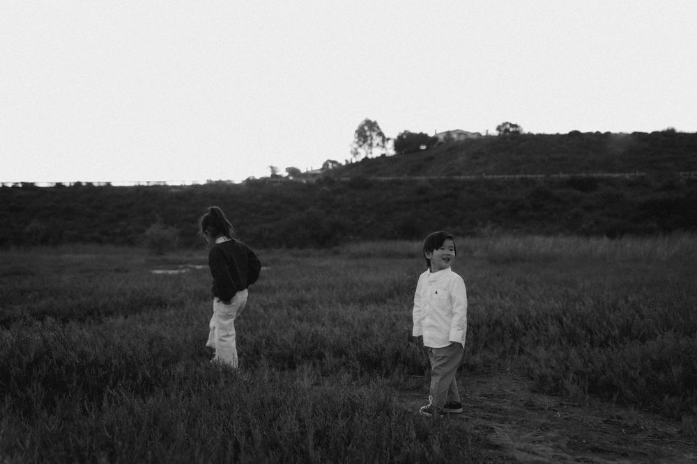 A black and white landscape photo of figures standing in a misty field.