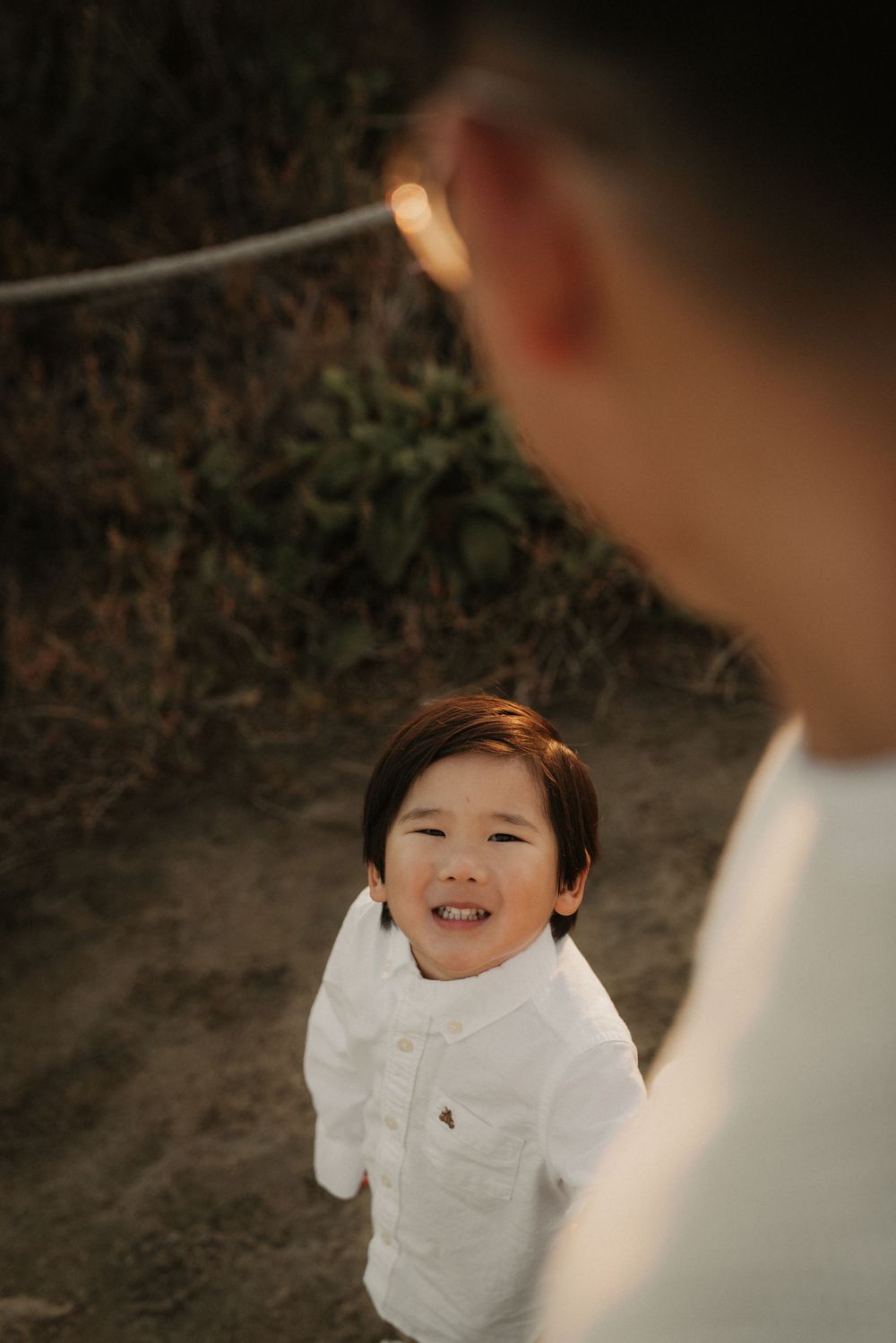 A candid moment captured on a nature trail showing a joyful expression in warm lighting.