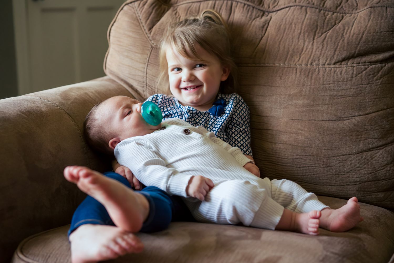 big sister holds newborn brother