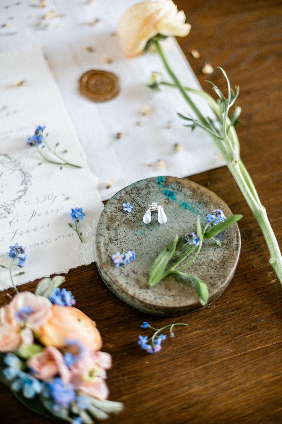 Vintage plate with delicate blue forget-me-nots and floral arrangements on a wooden table with antique paper.