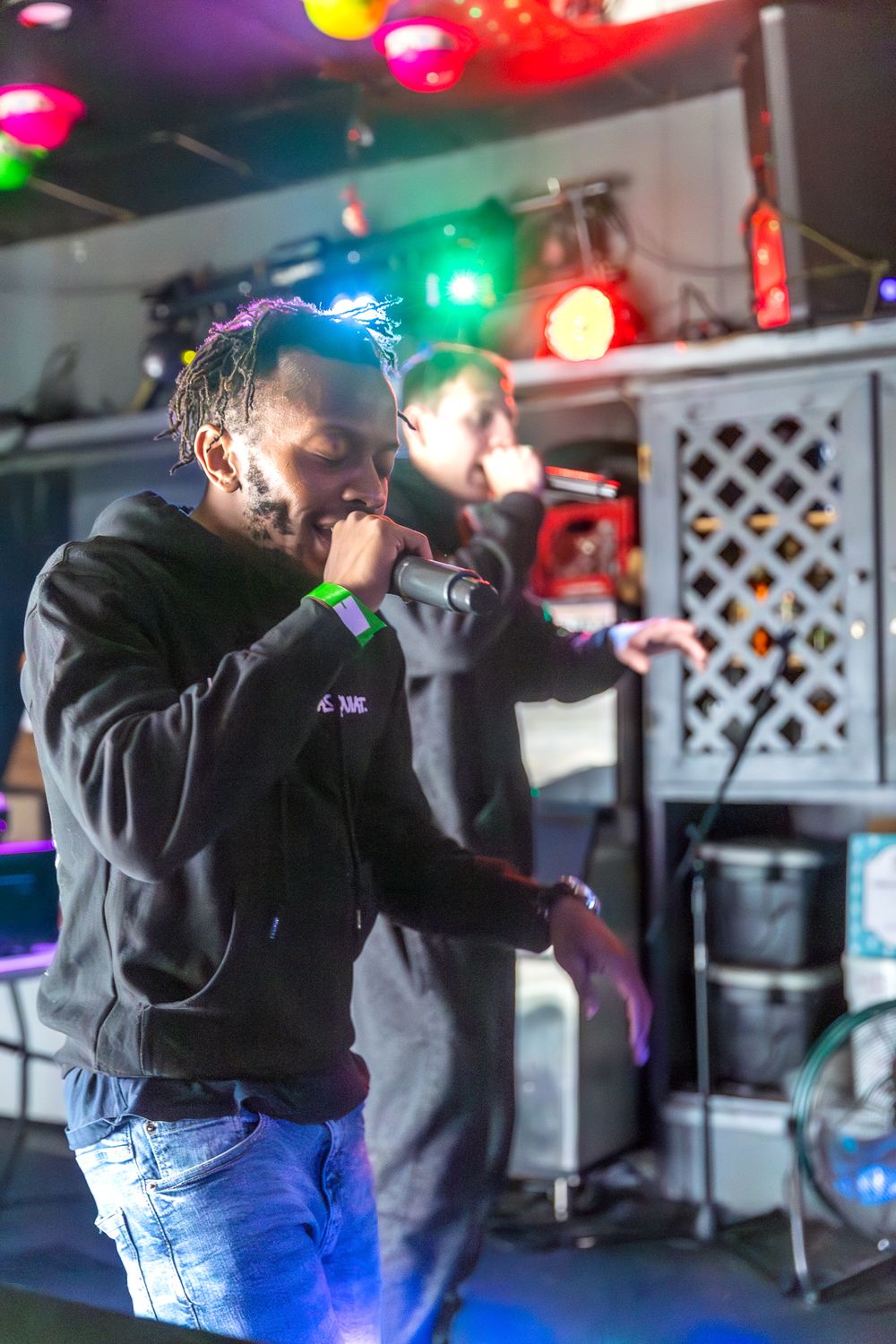 A performer on stage with colorful lighting effects at a nightclub venue.