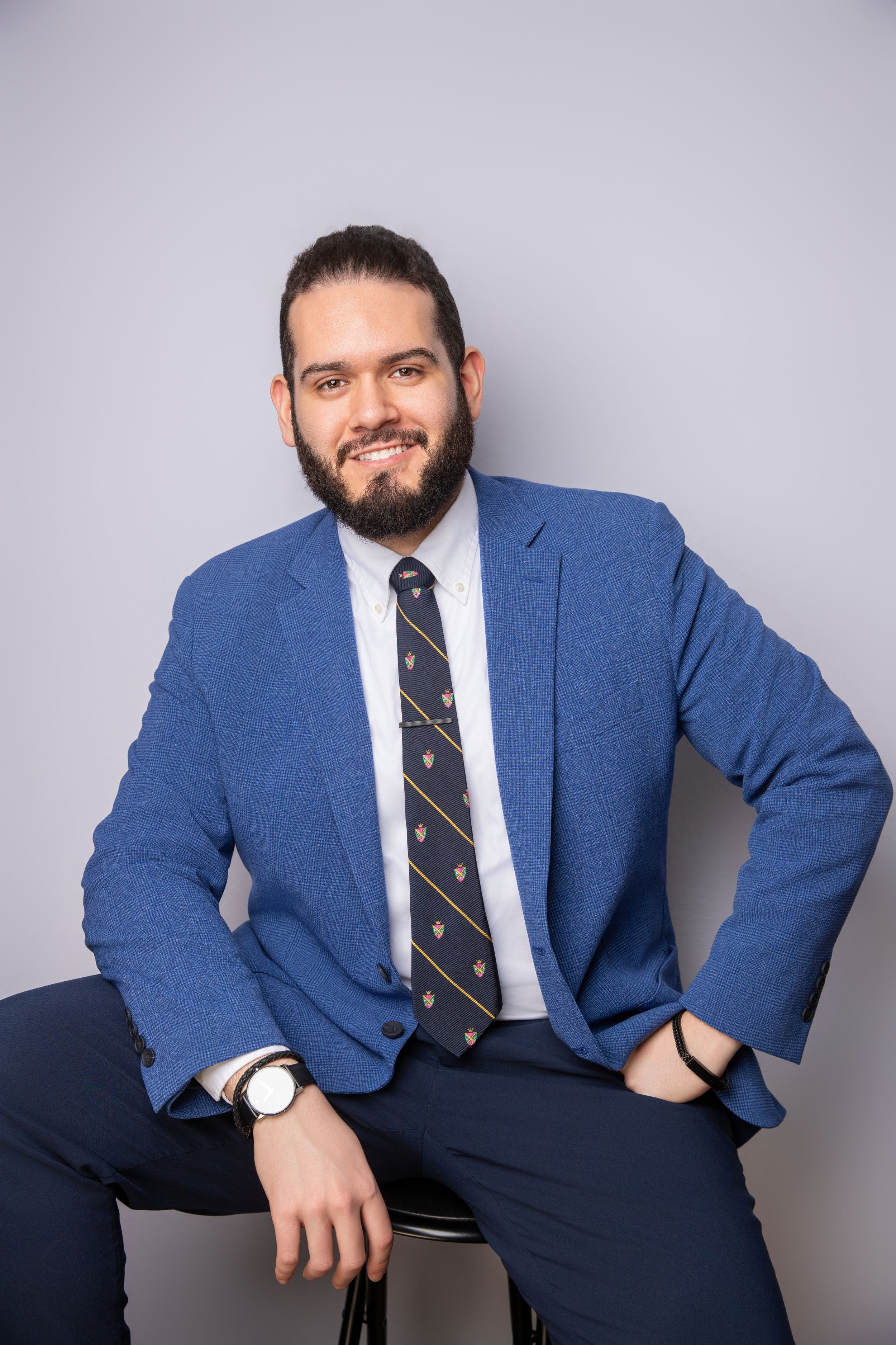 Business portrait headshots of man in blue suit and striped tie.