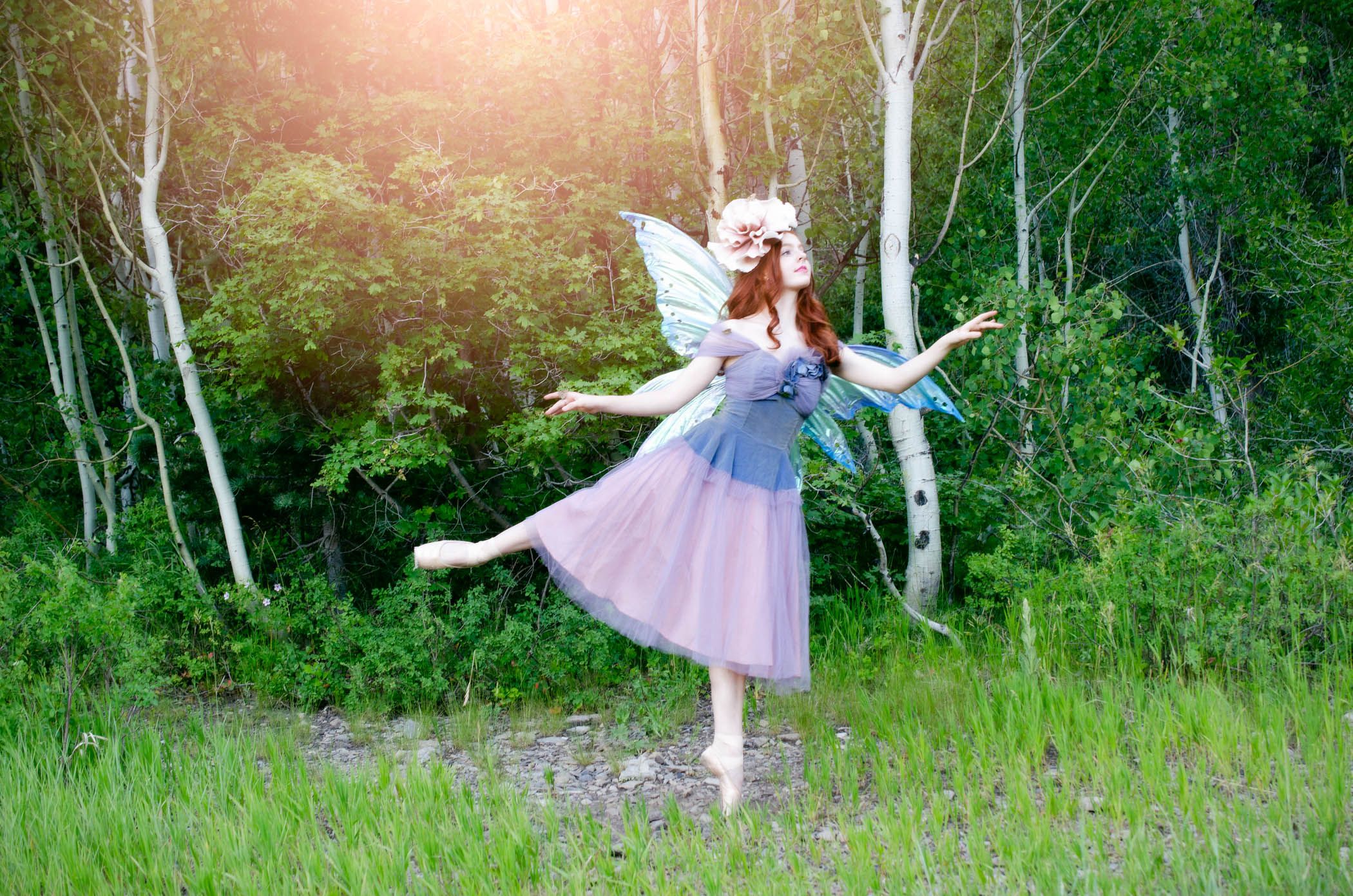 A ballerina in a vintage purple dress dances gracefully through a sunlit forest clearing among the trees in Aspen Grove.