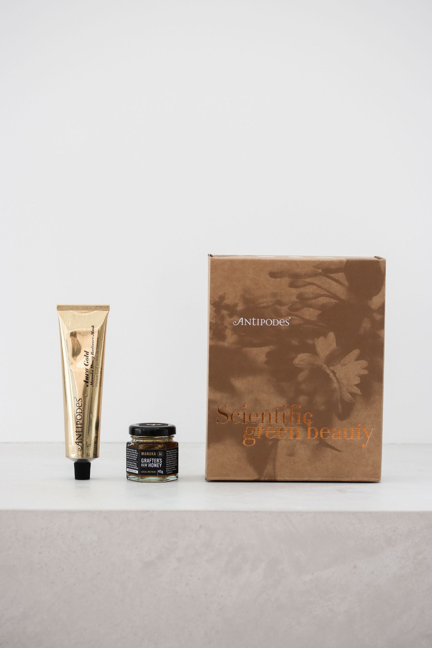 Luxury beauty products and packaging displayed on light gray surface.