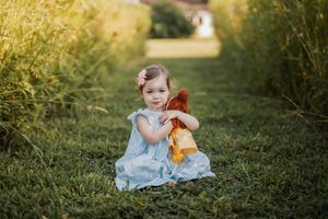 A collection of outdoor photos showing a child in a blue dress playing with a pumpkin on grassy ground at golden hour.