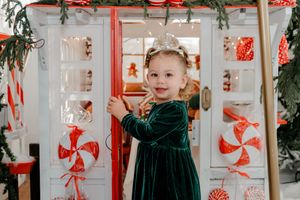 Christmas decorations and red ribbons adorn a bright white interior space with festive holiday ambiance.