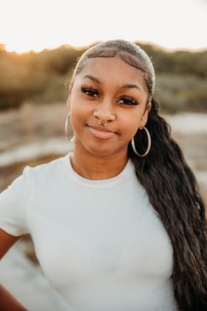 A beautiful portrait captured in golden hour lighting with hoop earrings and long dark hair.