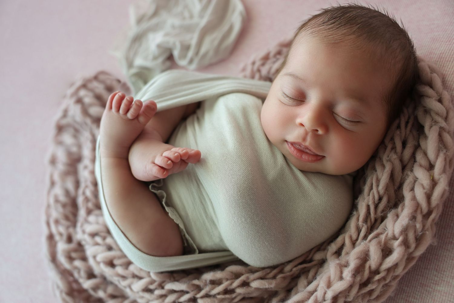 Newborn Boy with lots of dark black hair posed on front and peacefully sleeping for newborn session by Bump Birth and Beyond