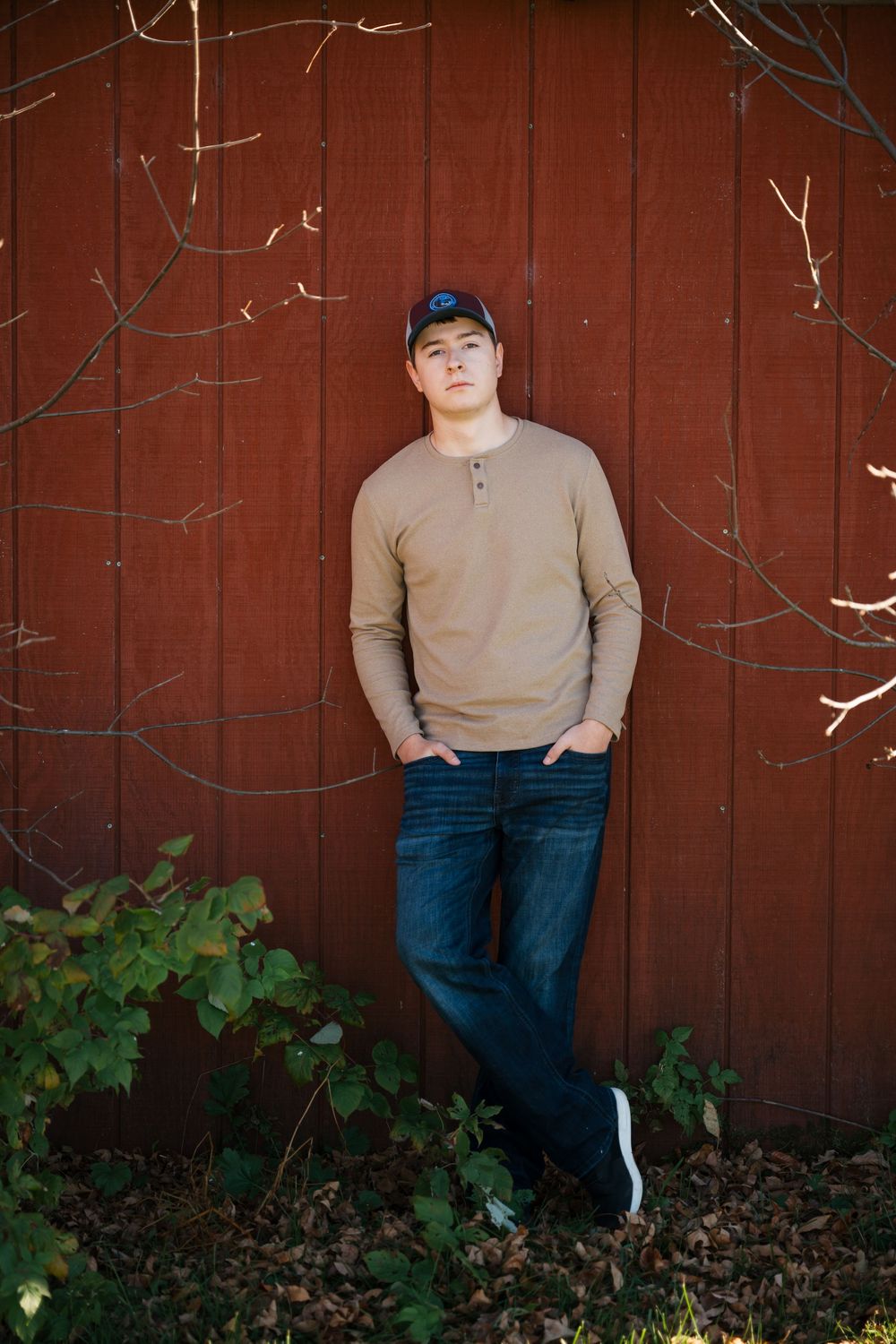 Senior high school posing against red barn door