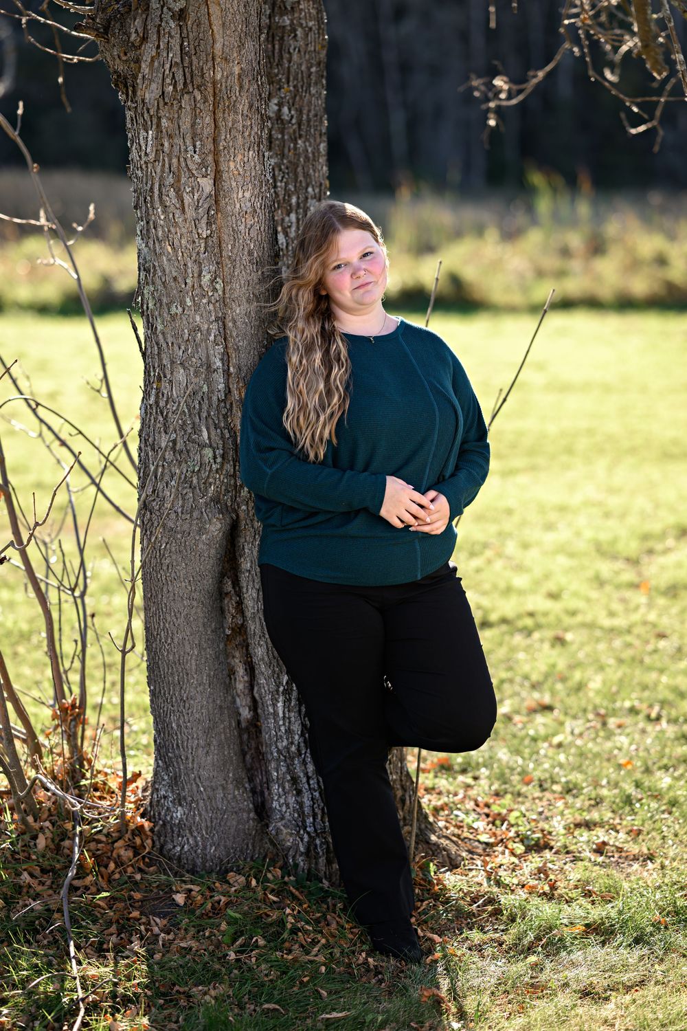 Siiri posing against tree for senior photosession Orr, MN