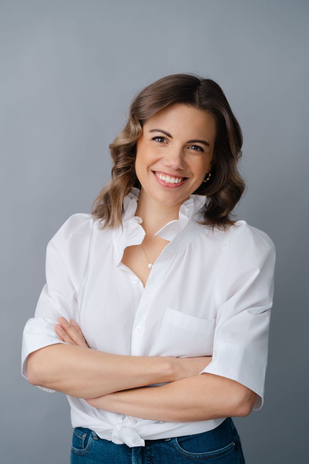 Professional portrait series showing person in white blouse against gray background with confident poses.