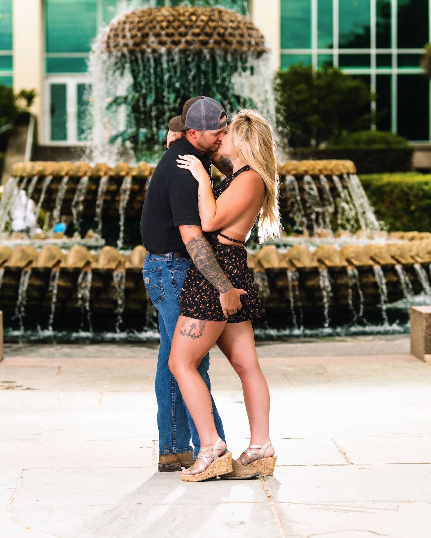Couple sharing intimate moment in front of tiered fountain. Charleston Photographer