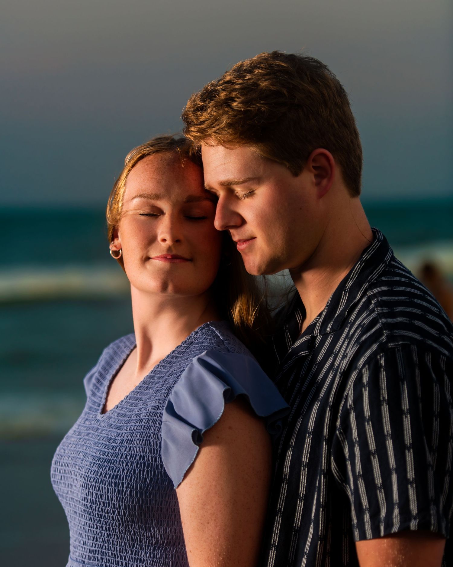 A tender moment between two people against an ocean backdrop at dusk. Myrtle beach photographer