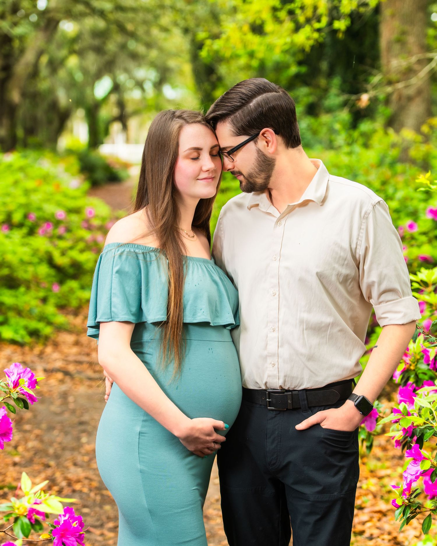 An expecting couple shares a tender moment. Charleston Photographer