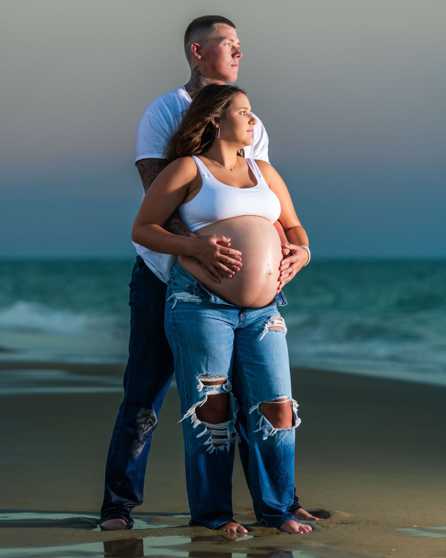 Expecting parents posing for maternity photos on oceanfront. Myrtle beach photographer
