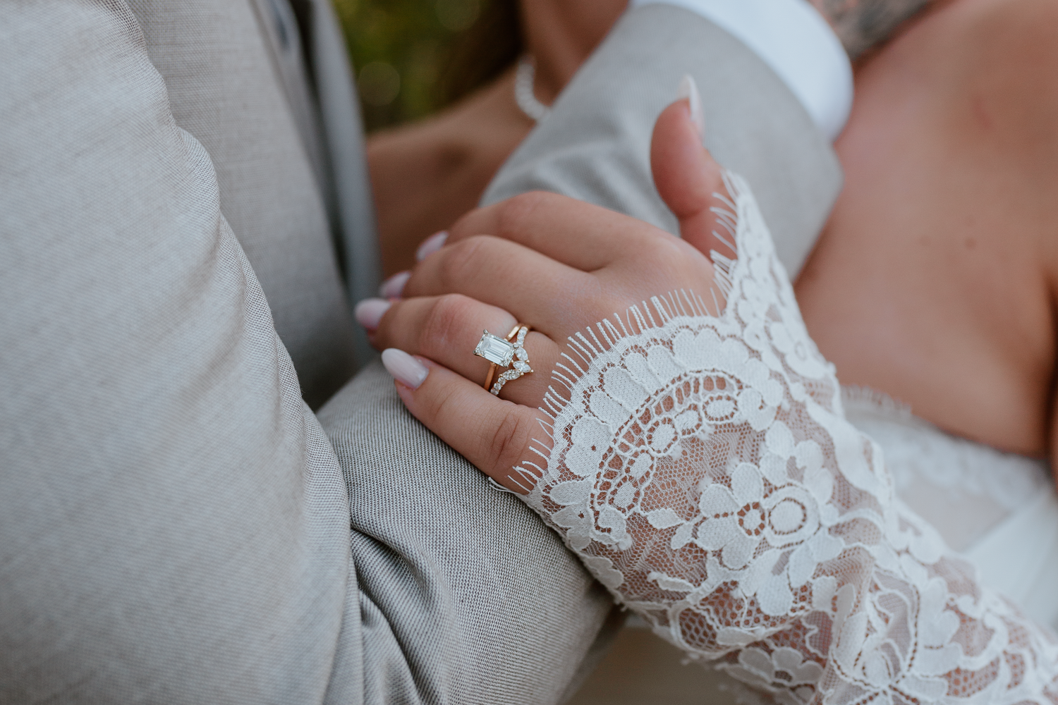 Bride and groom facing each other with his hand on her cheek and her hand on his arm smiling at each other.