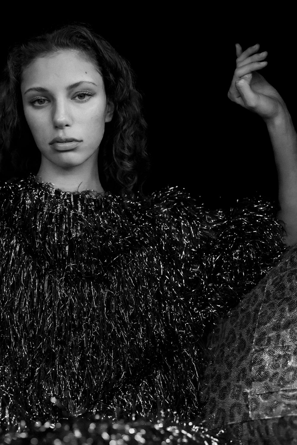 Artistic black and white fashion photograph featuring sparkly textured clothing.