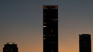 City skyscrapers silhouetted against an orange and purple twilight sky.