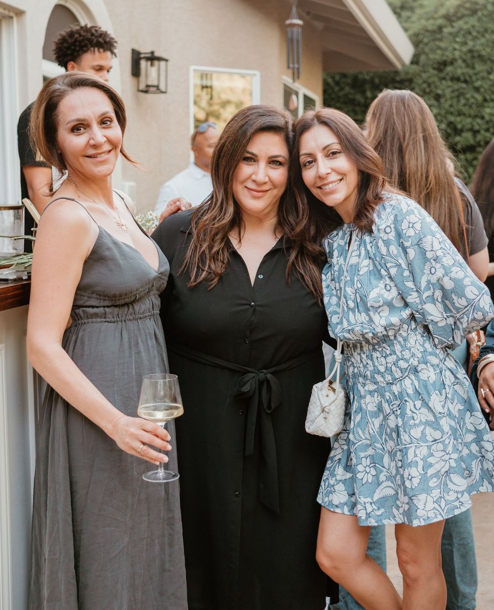 A group of friends in casual dresses gather together for a celebration.