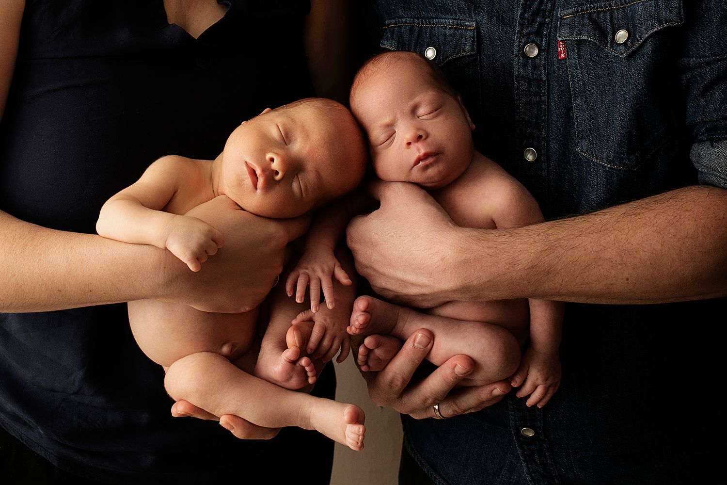 Artistic black and white newborn photography session with dramatic lighting.