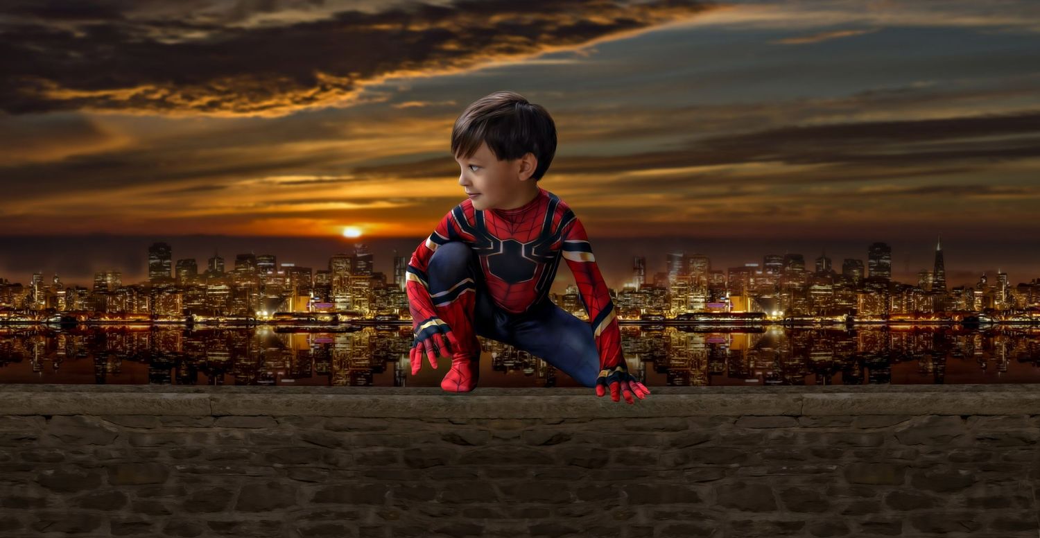 Dramatic sunset cityscape with superhero-themed silhouettes against an orange sky.