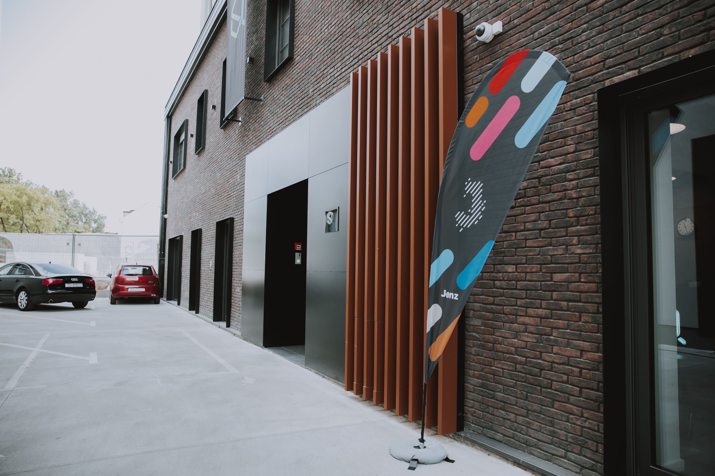 Modern building exterior with wood accents and colorful geometric wall art.