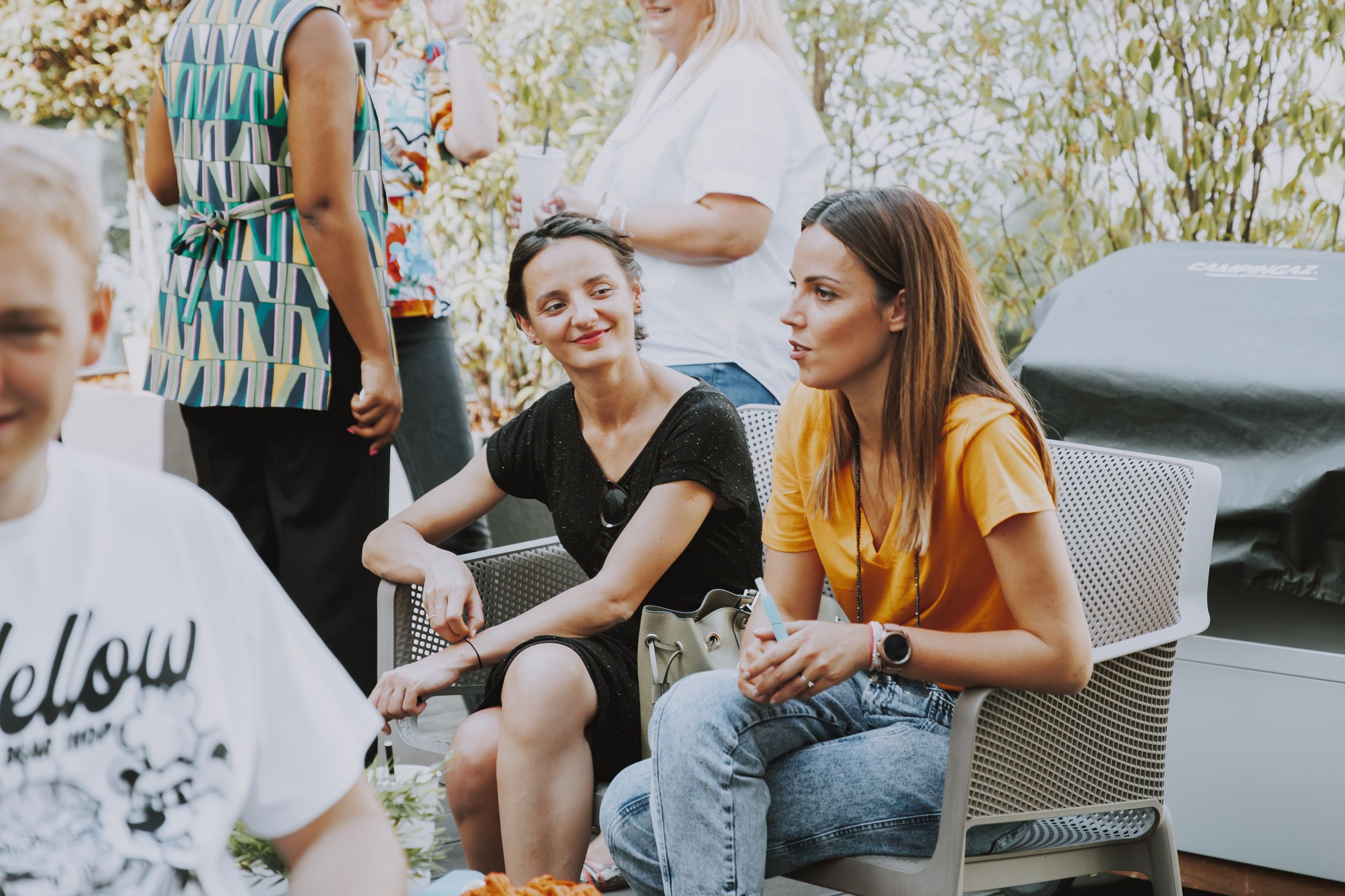 Group enjoying drinks and conversation at casual outdoor gathering.