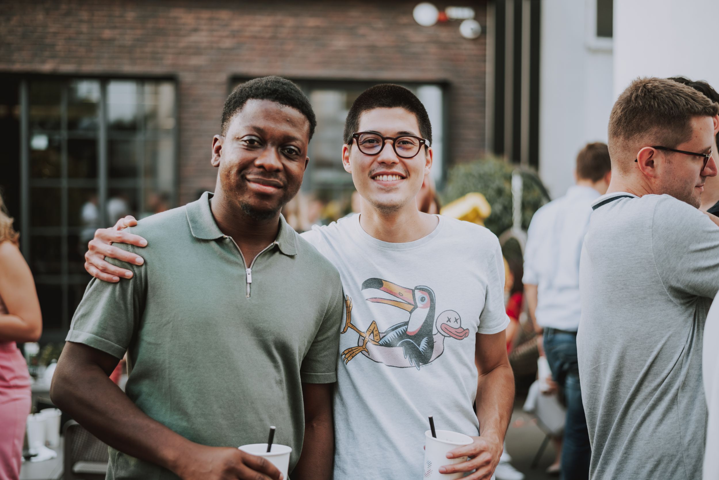 Two friends posing together at a casual outdoor social event.