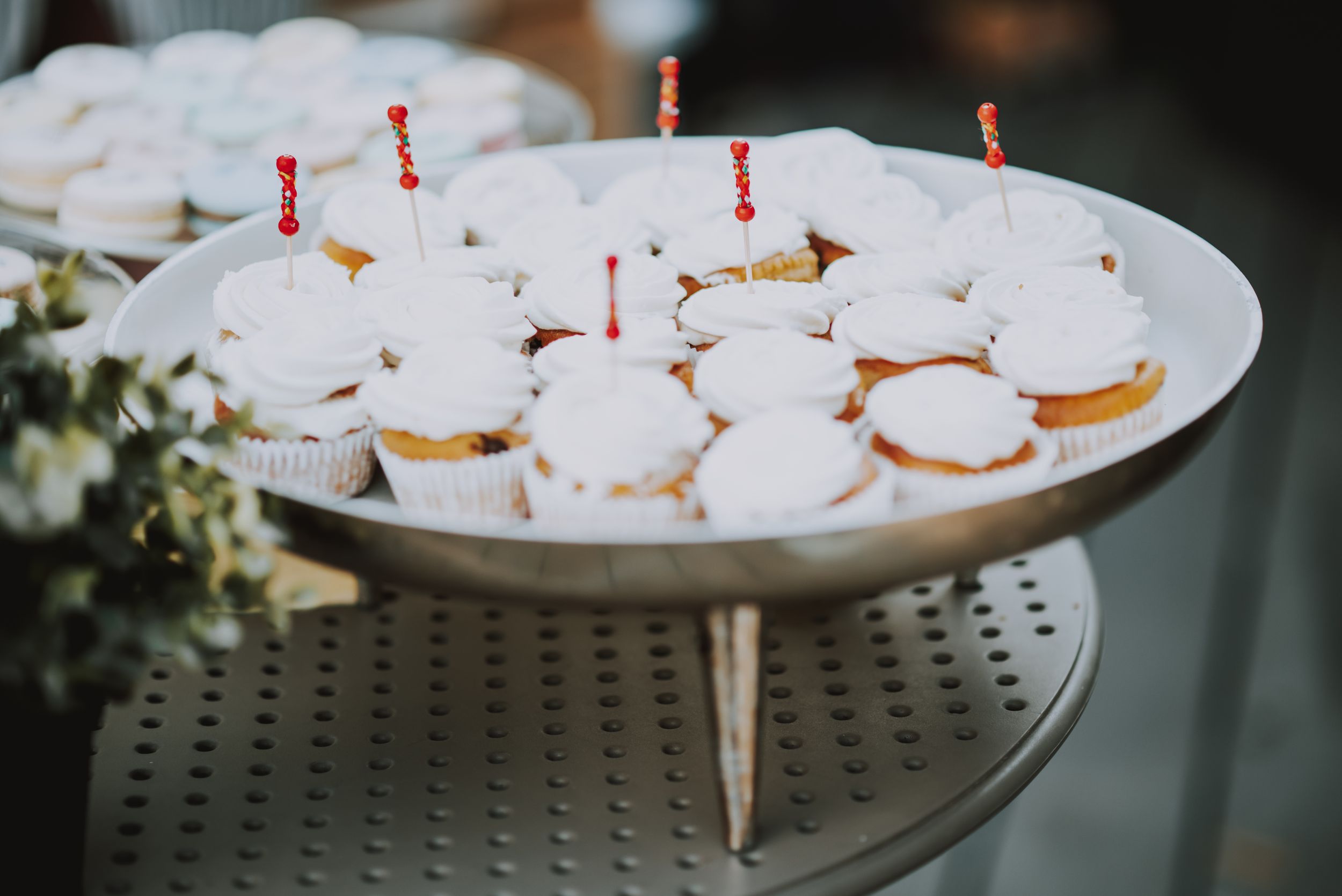 White frosted desserts with red candles arranged on a serving platter.