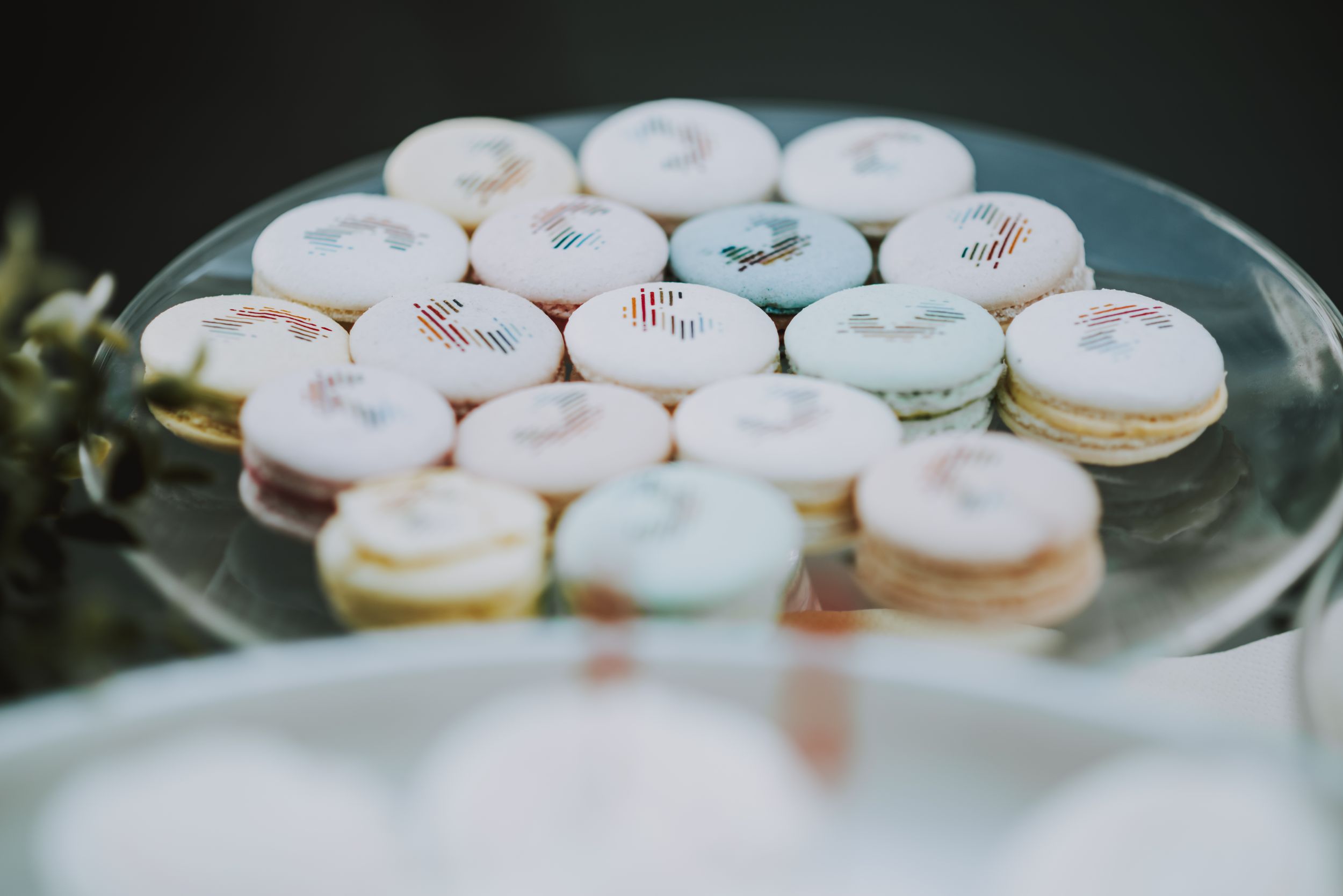 Plate of pastel colored macarons displayed on a glass serving platter.